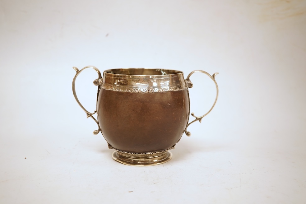 A late 19th/early 20th century white metal mounted two handled coconut cup, with engraved mounts and initials 'A IL', height 10cm (unmarked).